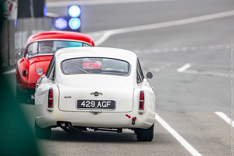 Aston Martin DB4 GT blanche, plaque 429 AGF, vue de l’arrière à la sortie de la voie des stands au Le Mans Classic 2023.
